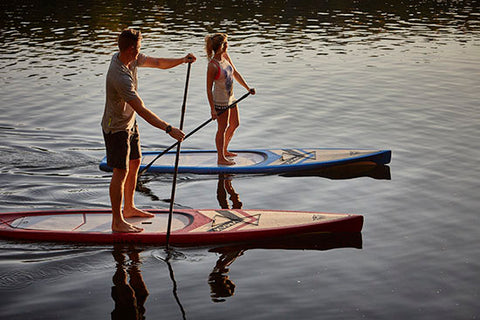 a couple stand up paddle boarding on touring SUP boards