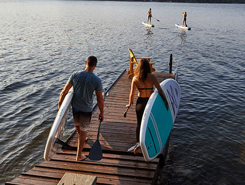 Stand up paddler boards carrying their boards with carry handle