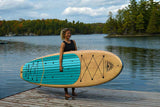 woman carrying a Cruiser SUP® stand up paddle board - Xplorer SE