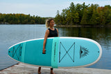 woman carrying a Cruiser SUP® stand up paddle board - Bliss Classic