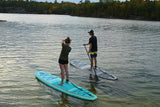 man and woman stand up paddle boarding on Cruiser SUP® Bliss LE on a lake