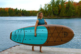 woman carrying a Cruiser SUP® stand up paddle board - Xplorer SE