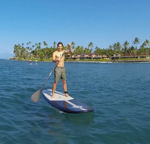 Stand Up Paddle Boarder Wearing a SUP Leash in Calm Water