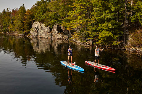 two stand up paddler boarders in calm water